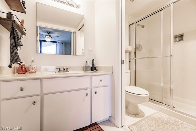 bathroom featuring toilet, ceiling fan, vanity with extensive cabinet space, an enclosed shower, and tile flooring