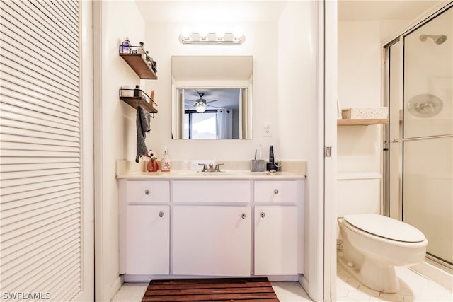 bathroom featuring toilet, a shower with door, ceiling fan, and vanity