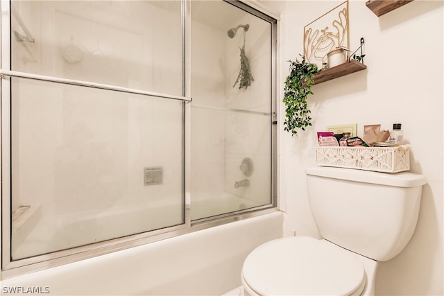 bathroom featuring combined bath / shower with glass door and toilet