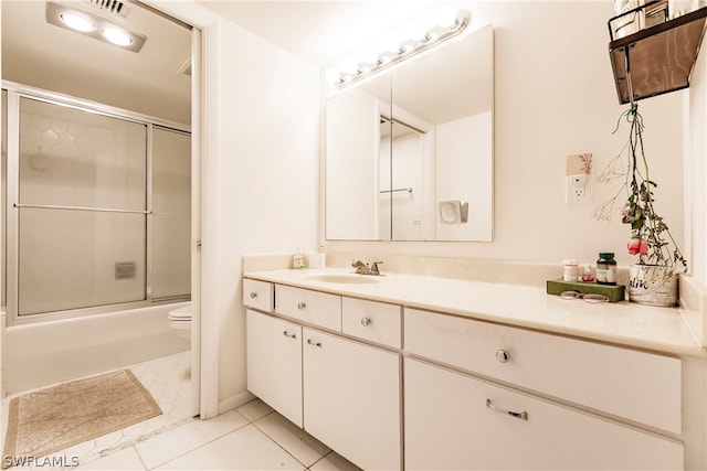 full bathroom featuring combined bath / shower with glass door, toilet, vanity, and tile flooring