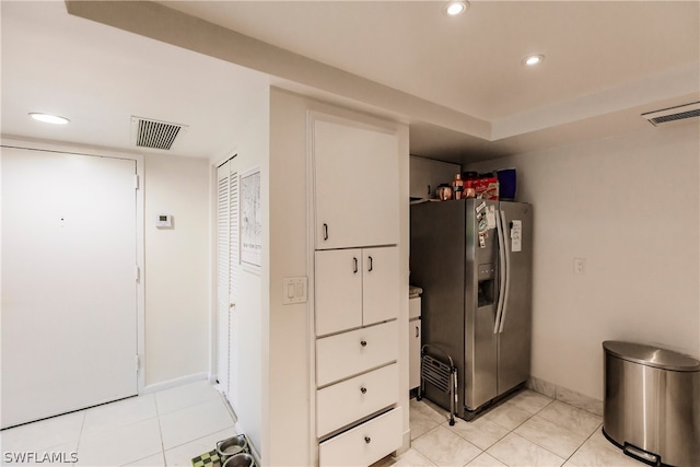 kitchen featuring stainless steel refrigerator with ice dispenser and light tile floors