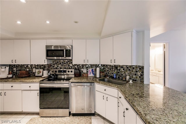 kitchen with sink, light tile floors, appliances with stainless steel finishes, and white cabinetry