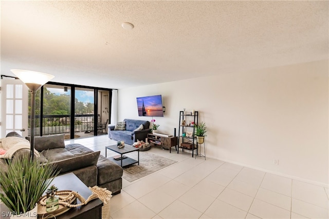 living room with a textured ceiling, light tile flooring, and a wall of windows