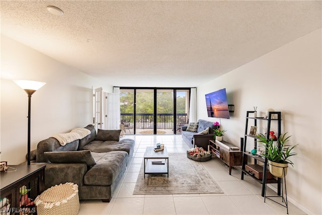 living room with expansive windows, light tile floors, and a textured ceiling