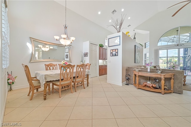 dining area with light tile floors, high vaulted ceiling, and a chandelier