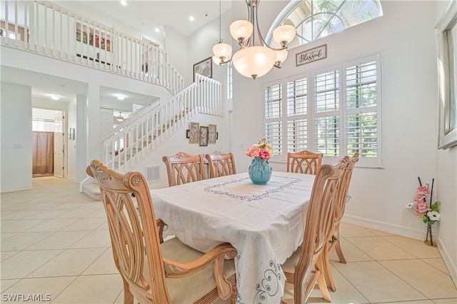 tiled dining room with a wealth of natural light, a towering ceiling, and an inviting chandelier