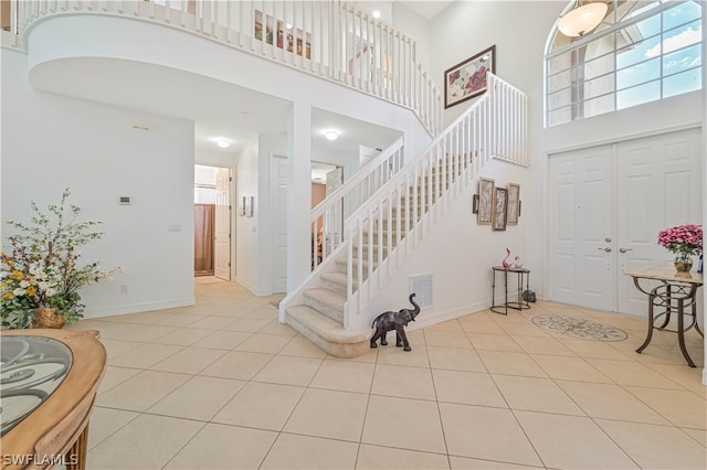 entrance foyer with light tile floors and a high ceiling