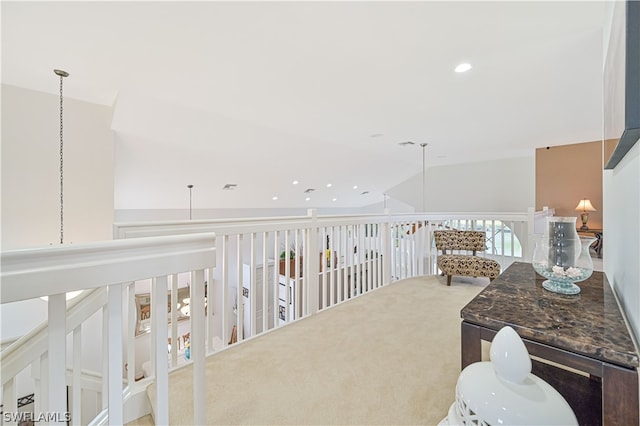 hall featuring light colored carpet and vaulted ceiling