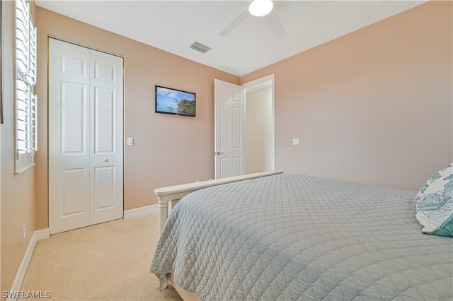 bedroom with light colored carpet, a closet, and ceiling fan