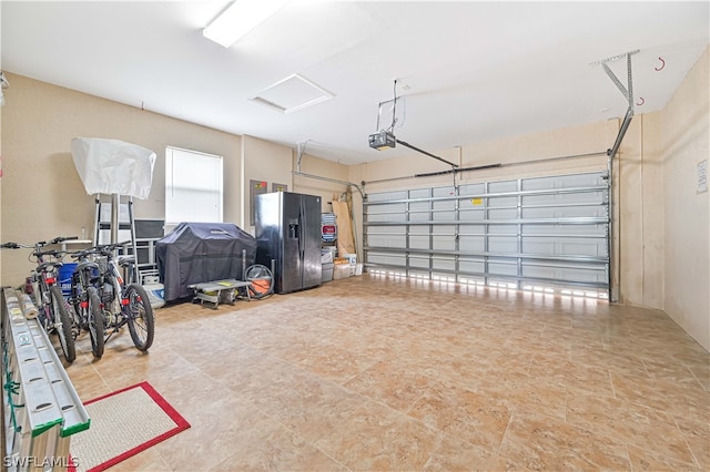 garage with black fridge and a garage door opener