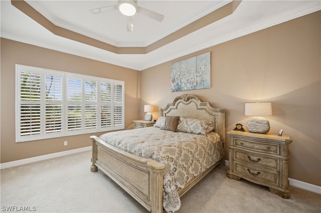 carpeted bedroom with crown molding, ceiling fan, and a tray ceiling