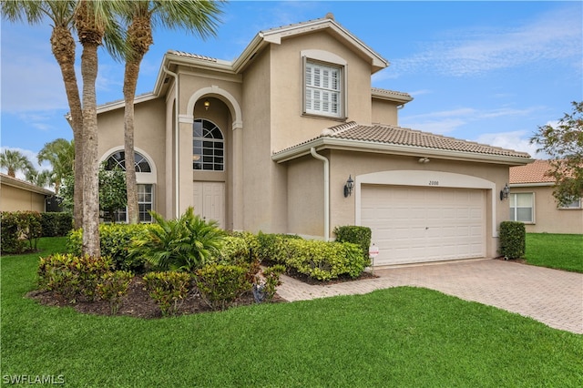 mediterranean / spanish house with a front lawn and a garage