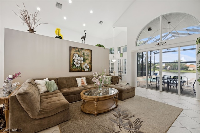 tiled living room with a water view and a high ceiling