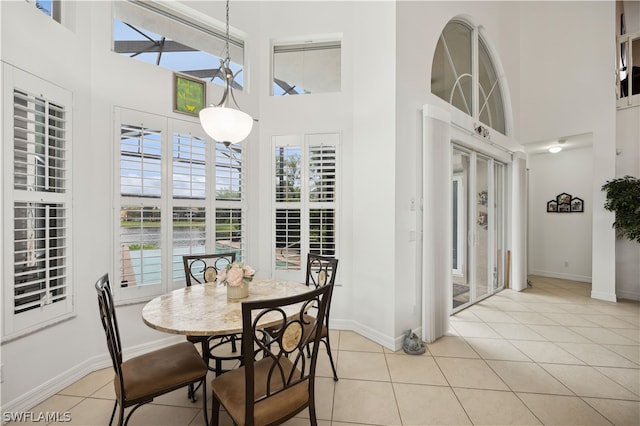 tiled dining space with a high ceiling