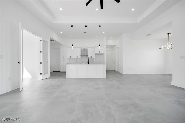 unfurnished living room with recessed lighting, baseboards, and ceiling fan with notable chandelier