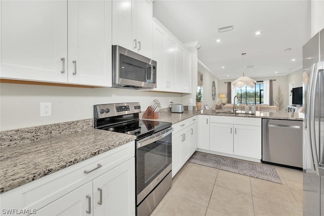 kitchen with appliances with stainless steel finishes, light tile floors, white cabinets, sink, and kitchen peninsula