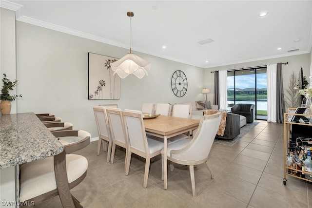 tiled dining space featuring ornamental molding, a baseboard radiator, and a water view