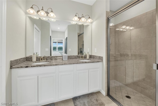 bathroom with tile flooring, a shower with door, and double sink vanity