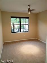 carpeted spare room featuring ceiling fan