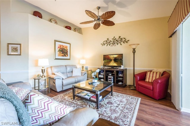 living room featuring ceiling fan and dark hardwood / wood-style floors