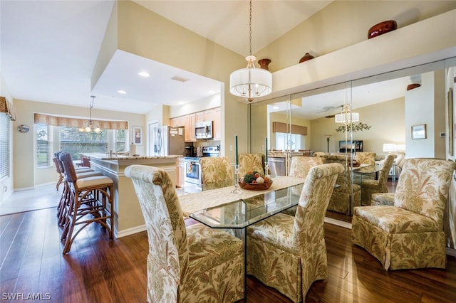 dining space featuring dark hardwood / wood-style floors and an inviting chandelier