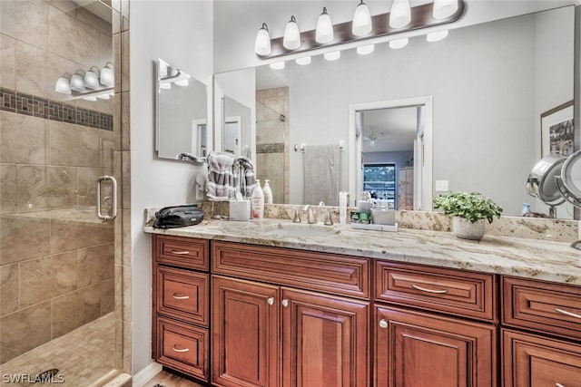 bathroom featuring ceiling fan, vanity, and a shower with shower door