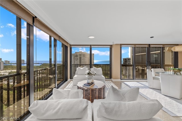 living room featuring french doors, a water view, and a wall of windows