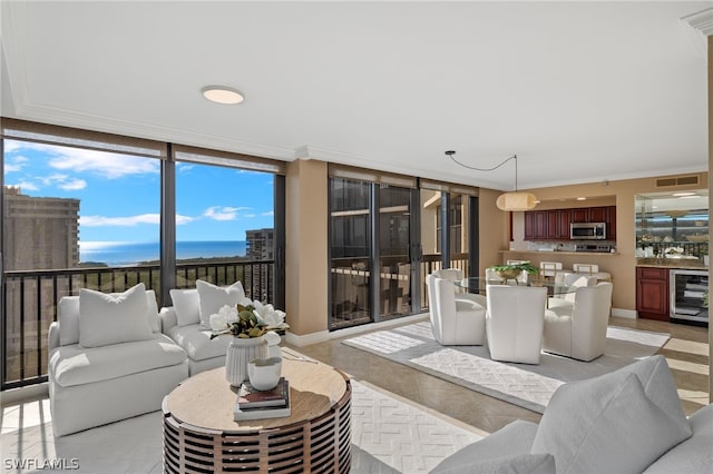 tiled living room with a water view, beverage cooler, and crown molding