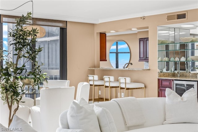 living room with wine cooler and crown molding