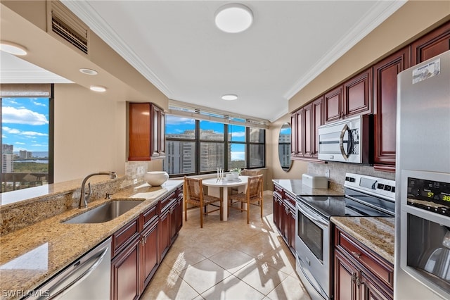 kitchen with appliances with stainless steel finishes, sink, light stone counters, tasteful backsplash, and crown molding