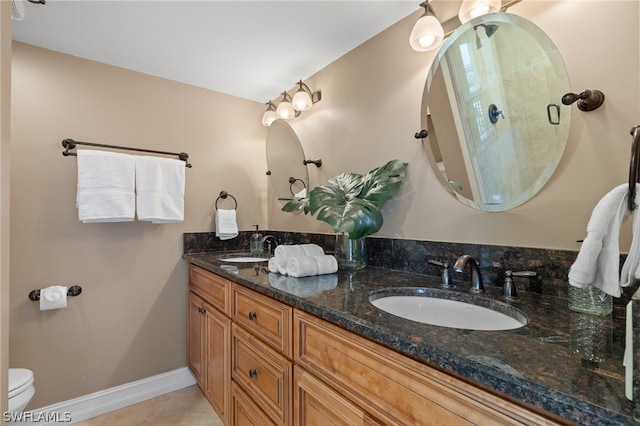 bathroom with toilet, tile flooring, and dual vanity