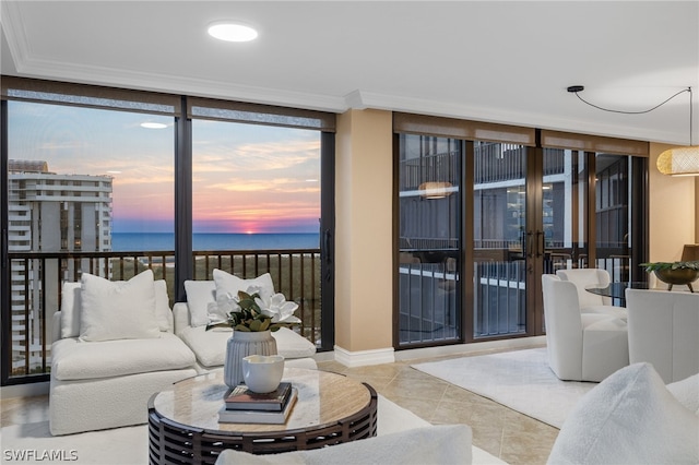 living room with a water view, floor to ceiling windows, ornamental molding, and light tile floors