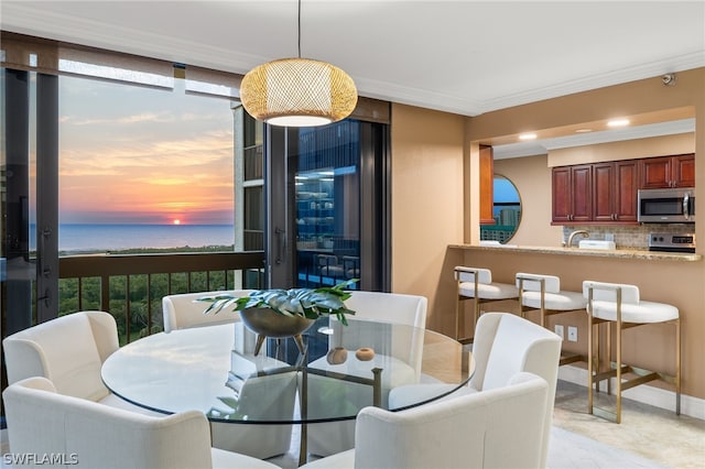 dining space with light tile flooring and a water view