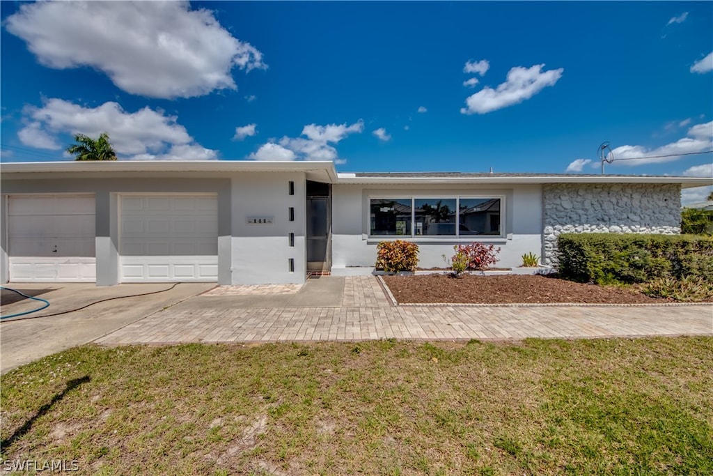 ranch-style home with a front yard and a garage