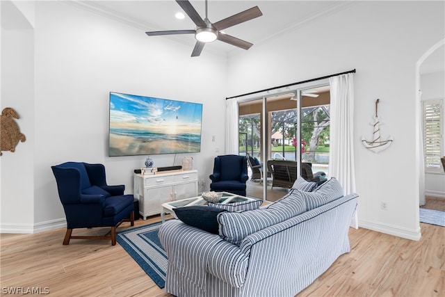 living room with crown molding, plenty of natural light, and light wood-type flooring