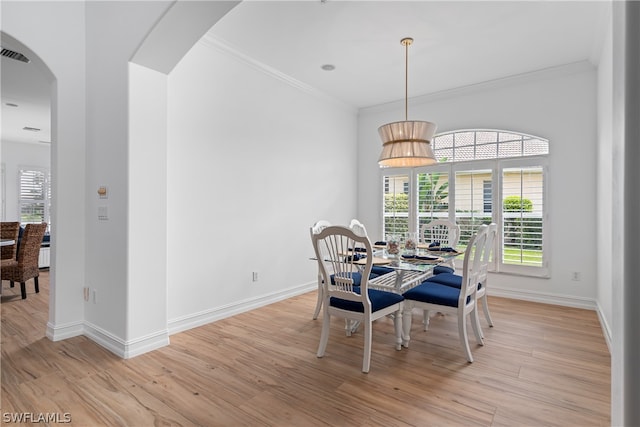 dining space with light hardwood / wood-style flooring and ornamental molding