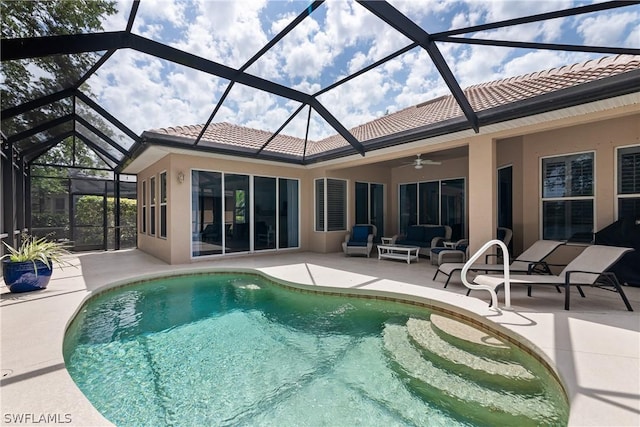 view of pool with a patio, ceiling fan, and glass enclosure