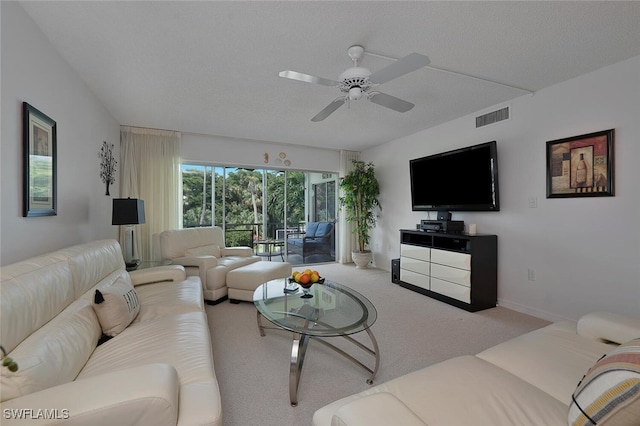 living room with a textured ceiling, carpet flooring, and ceiling fan