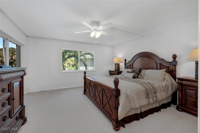 bedroom with ceiling fan, light colored carpet, and multiple windows