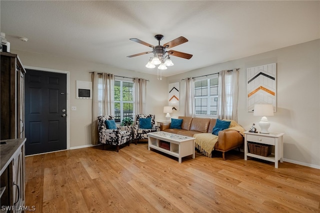 living room with light hardwood / wood-style floors and ceiling fan