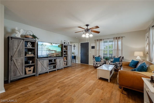 living room with ceiling fan and light hardwood / wood-style flooring