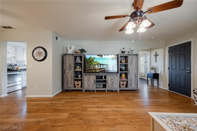 unfurnished living room with ceiling fan and light wood-type flooring