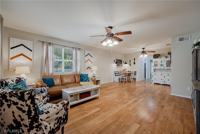 living room with light hardwood / wood-style floors and ceiling fan