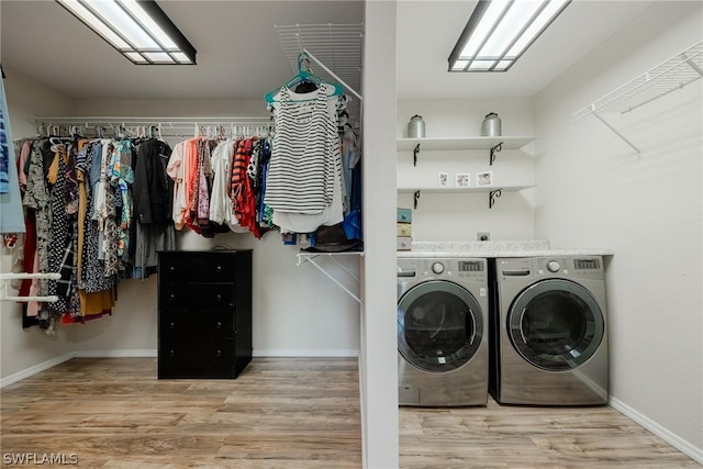 laundry area with independent washer and dryer and light wood-type flooring