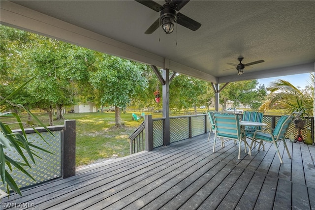 deck with a lawn and ceiling fan