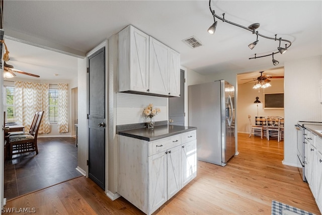 kitchen with white cabinets, stainless steel fridge, ceiling fan, and rail lighting