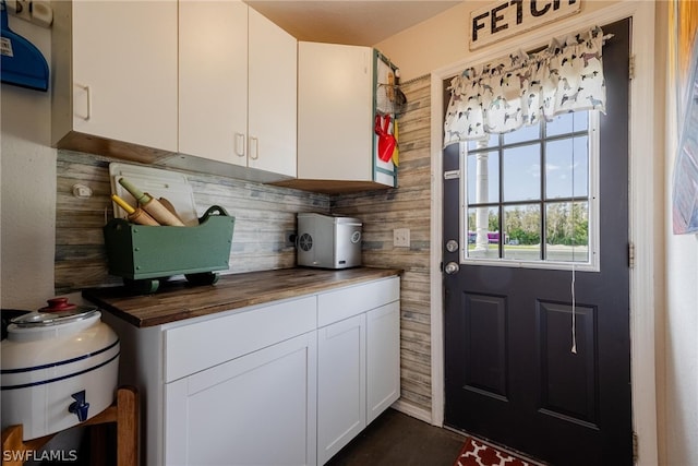 kitchen with backsplash, butcher block countertops, and white cabinets