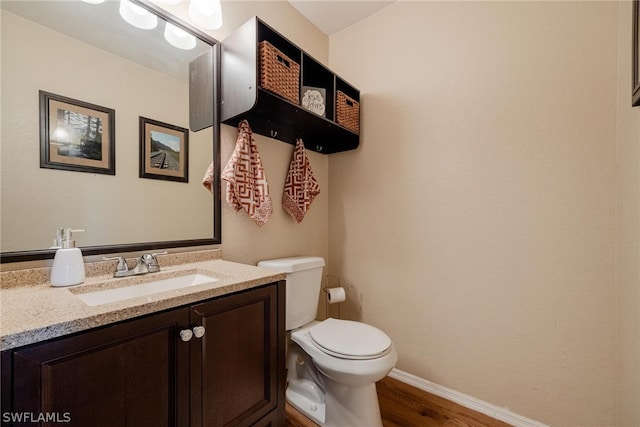 bathroom featuring toilet, wood-type flooring, and vanity