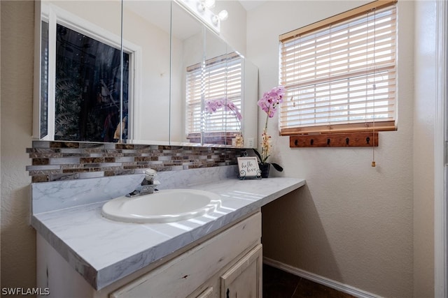 bathroom featuring tile flooring, vanity with extensive cabinet space, and tasteful backsplash