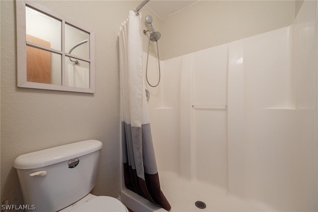 bathroom with a shower with curtain and toilet